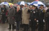 2012 Memorial Service - guests paying respects at memorial service in the rain with umbrellas (7)